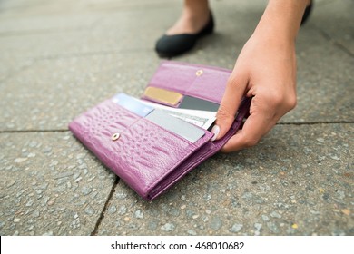 Close-up Of A Woman Picking Up Fallen Wallet On Street