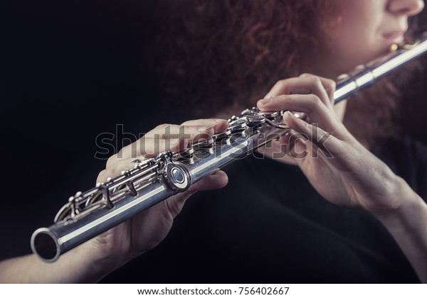 Close-up of\
a woman playing the flute. Musical\
concept