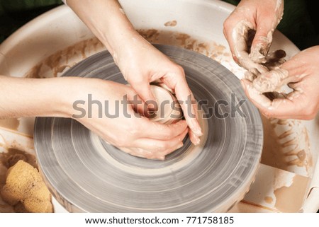 Similar – Young female sitting by table and making clay or ceramic mug