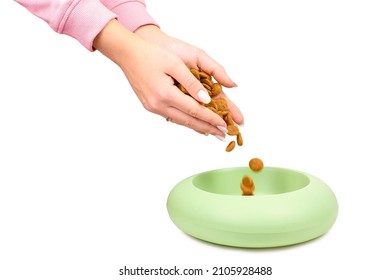 Close-up Woman Pouring Dry Dog Food Into A Bowl Isolated On White Background