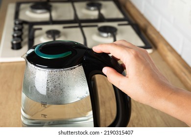 Close-up Of A Woman Pressing The Power Switch On An Electric Kettle.Kettle For Boiling Water And Making Tea.Home Appliances For Making Hot Drinks.Space For Copy.Place For Text.