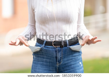 Close-up of a woman pulling tissue out of trouser pockets with no money.
