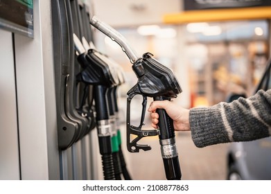 Cierre de una mujer bombeando combustible de gasolina en un auto en una gasolinera. Gasolina o gasolina que se bombea en un motor. Concepto de transporte
