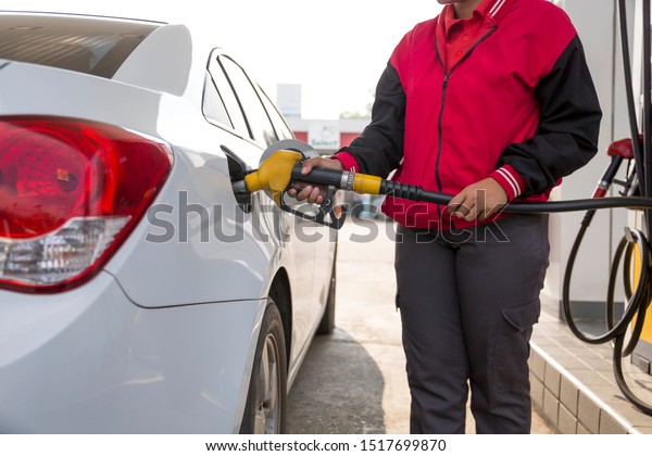 Closeup\
of woman pumping gasoline fuel in car at gas station. Petrol or\
gasoline being pumped into a motor vehicle\
car.