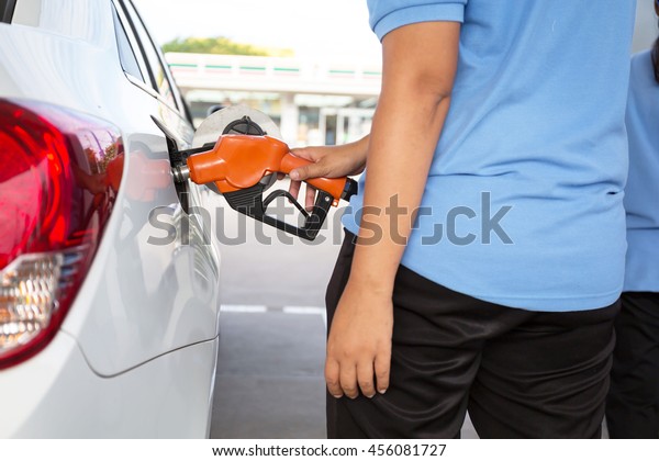 Closeup\
of woman pumping gasoline fuel in car at gas station. Petrol or\
gasoline being pumped into a motor vehicle\
car.\
