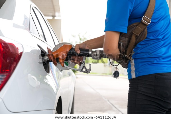 \
Closeup\
of woman pumping gasoline fuel in car at gas station. Petrol or\
gasoline being pumped into a motor vehicle\
car.