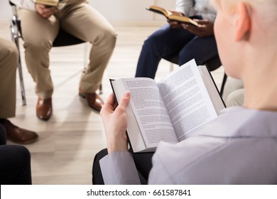 Close-up Of A Woman Reading Bible In Group