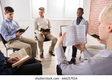 Close-up Of A Woman Reading Bible In Group