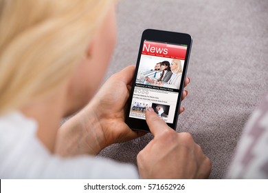 Close-up Of A Woman Reading News On Mobile Phone