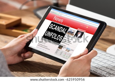 Close-up Of A Woman Reading Scandal News On Digital Tablet