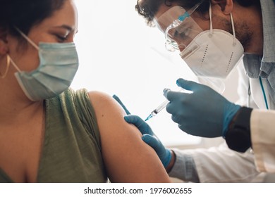 Close-up Of A Woman Receiving Covid-19 Vaccine At Home. Healthcare Worker Vaccinating A Female In Face Mask At Home.