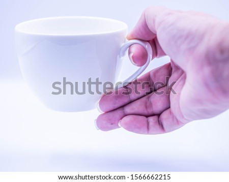 Similar – Foto Bild Frau Hand, die eine Tasse Kaffee von einem Holztisch im Garten aufzieht.