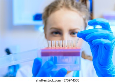 Closeup of woman scientist chemist doing analysis, working with test tubes in modern laboratory