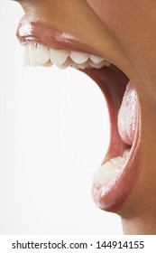 Closeup Of Woman Screaming With Mouth Wide Open Over White Background