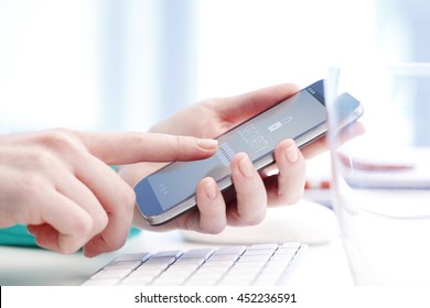 Close-up Of A Woman Sitting In Front Of Laptop And Using Her Mobile Phone While Login E-bank. 