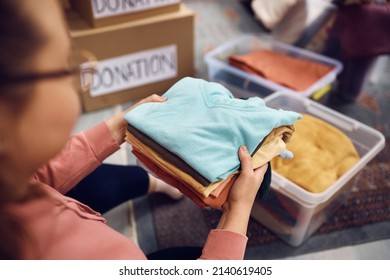 Close-up of woman sorting wardrobe into boxes for the charity.  - Powered by Shutterstock