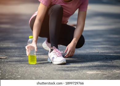 Close-up of woman sport athletes and electrolytes. Asian woman dehydrated sweating after outdoor running exercise.