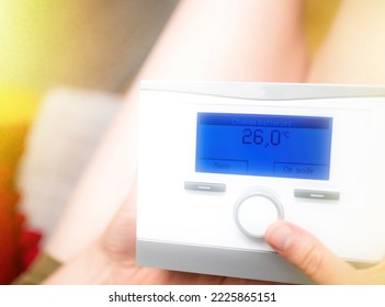 Close-up Of Woman Turning Dial Wheel Of A Connected Thermostat With Special Message On The Digital Blue Dot Matrix Display Screen - Change Batteries - Warm Weather Inside Appartment House Home