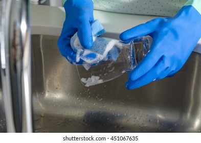 Closeup of woman washing a glass in the sink. - Shutterstock ID 451067635