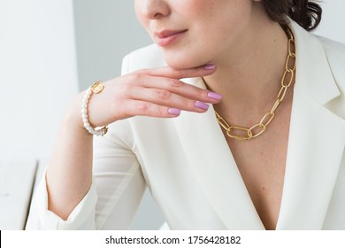 Close-up Of Woman Wearing A Gold Necklace And Bracelet. Jewelry, Bijouterie And Accessories Concept.