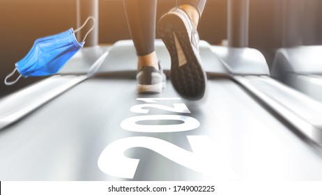 Close-up Of Woman Wearing Sports Shoes Running On A Treadmill In A Gym After The Covid-19 Coronavirus Disappeared. Taking Off The Face Mask And Move On To The Year 2021 With Healthy Life.