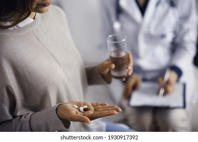 Close-up woman-patient holding pills near her doctor, time to take medications, cure for headache or remedy pain killer drugs. Stay at home concept during Coronavirus pandemic and self isolation