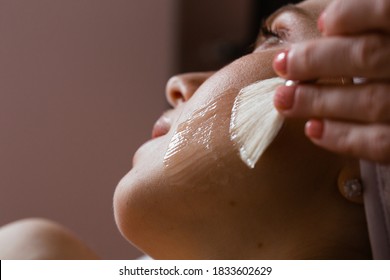 Close-up of a woman's face. The beautician makes a chemical peel. Skin care concept.