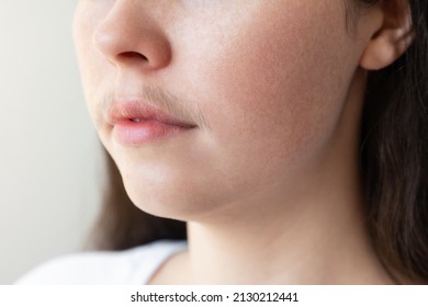 A close-up of a woman's face with a mustache over her upper lip. The concept of hair removal and epilation.