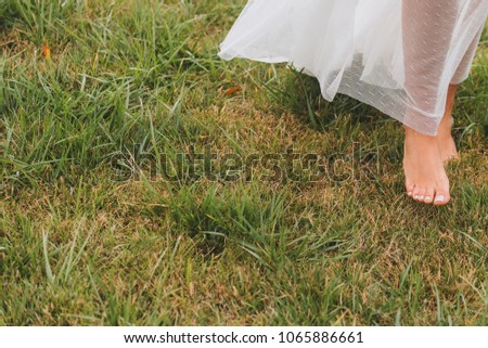 Close-up of a woman's feet walking barefoot on grass
