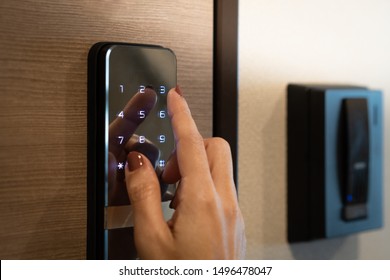 Closeup of a woman's finger entering password code on the smart digital touch screen keypad entry door lock in front of the room. Self Check-in, Airbnb, Modern security, Keyless, Temporary codes.