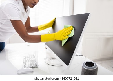 Close-up Of A Woman's Hand Cleaning Desktop Screen With Green Rag In Office - Powered by Shutterstock