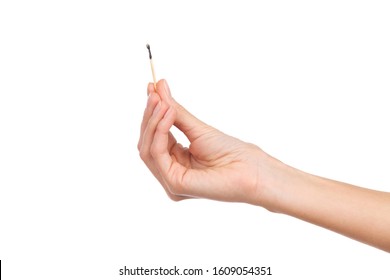 Closeup Of Woman's Hand Holding Burnt Matchstick. Studio Shot Isolated On White.