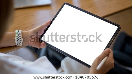 Close-up of a woman's hand holding a tab with a blank screen