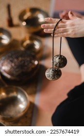 Close-up of a woman's hand holding Tibetan bells for sound therapy. Tibetan cymbals.