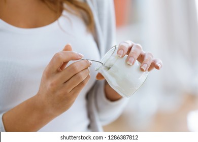 Close-up Of Woman's Hand Holding Yogurt While Eating At Home.