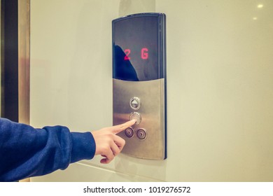 Close-up of woman's hand pushing a button of elevator