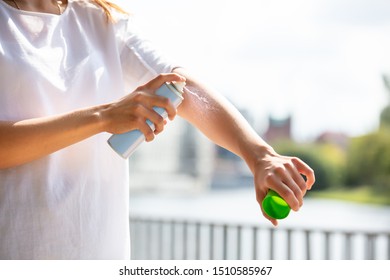 Close-up Of A Woman's Hand Spraying Anti Insect Deet Spray On Skin Outdoors
