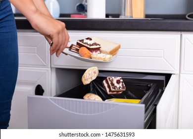 Close-up Of A Woman's Hand Throwing Food In Trash Bin