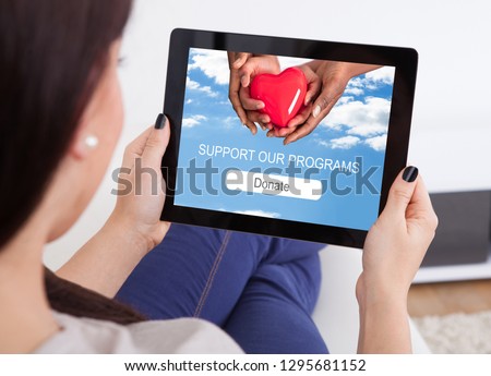 Close-up Of A Woman's Hand Using Digital Tablet For Donation