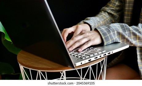 Close-up Of Woman's Hands In A Jacket Typing On A Laptop Computer. The Person Works, Studies At Home Online. No Face.