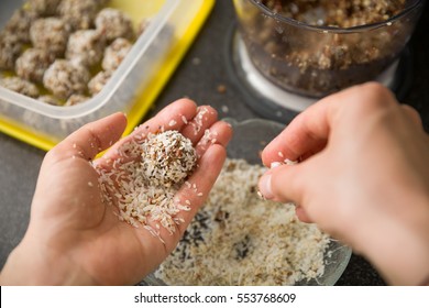 Closeup of woman's hands making healthy sweet treats. Cooking chocolate protein balls with nuts and peanut butter. Healthy lifestyle.