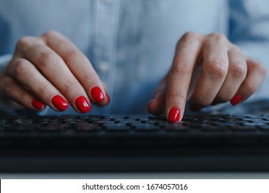 Closeup of woman's hands with red nails typing on a black keyboard wearing blue shirt at a workplace desk. Business, freelance, self-employment. Distance job and online work concept - Powered by Shutterstock