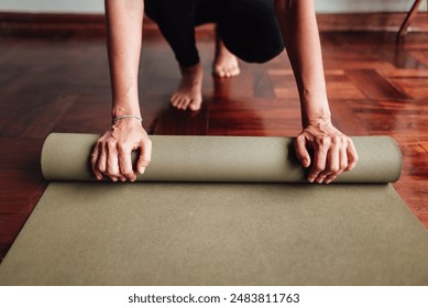 Close-up of a woman's hands rolling up the yoga mat. Concept of wellness. - Powered by Shutterstock