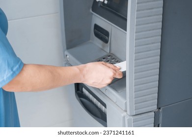 Close-up of woman's hands using ATM with contactless nfs access. 