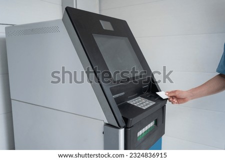 Close-up of woman's hands using ATM with contactless nfs access. 