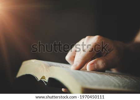 Close-up of woman's hands while reading the Bible.