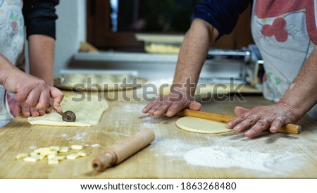 Close-up of woman's hands working the dough to prepare cheese ravioli. Traditional Sardinian cuisine.