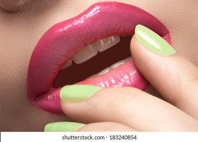 Close-up Of Woman's Lips With Fashion Hot Pink Lipstick Makeup. Beauty Macro Sexy Make-up With Bright Mint Green Color On Nails. 