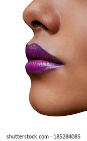 Closeup Of Woman's Sexy Lips With Purple Style Lipstick On Tanned Skin. Profile Shot On White Studio Background