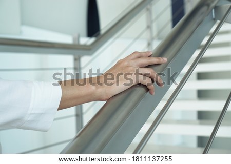Closeup women hand holding handrail
